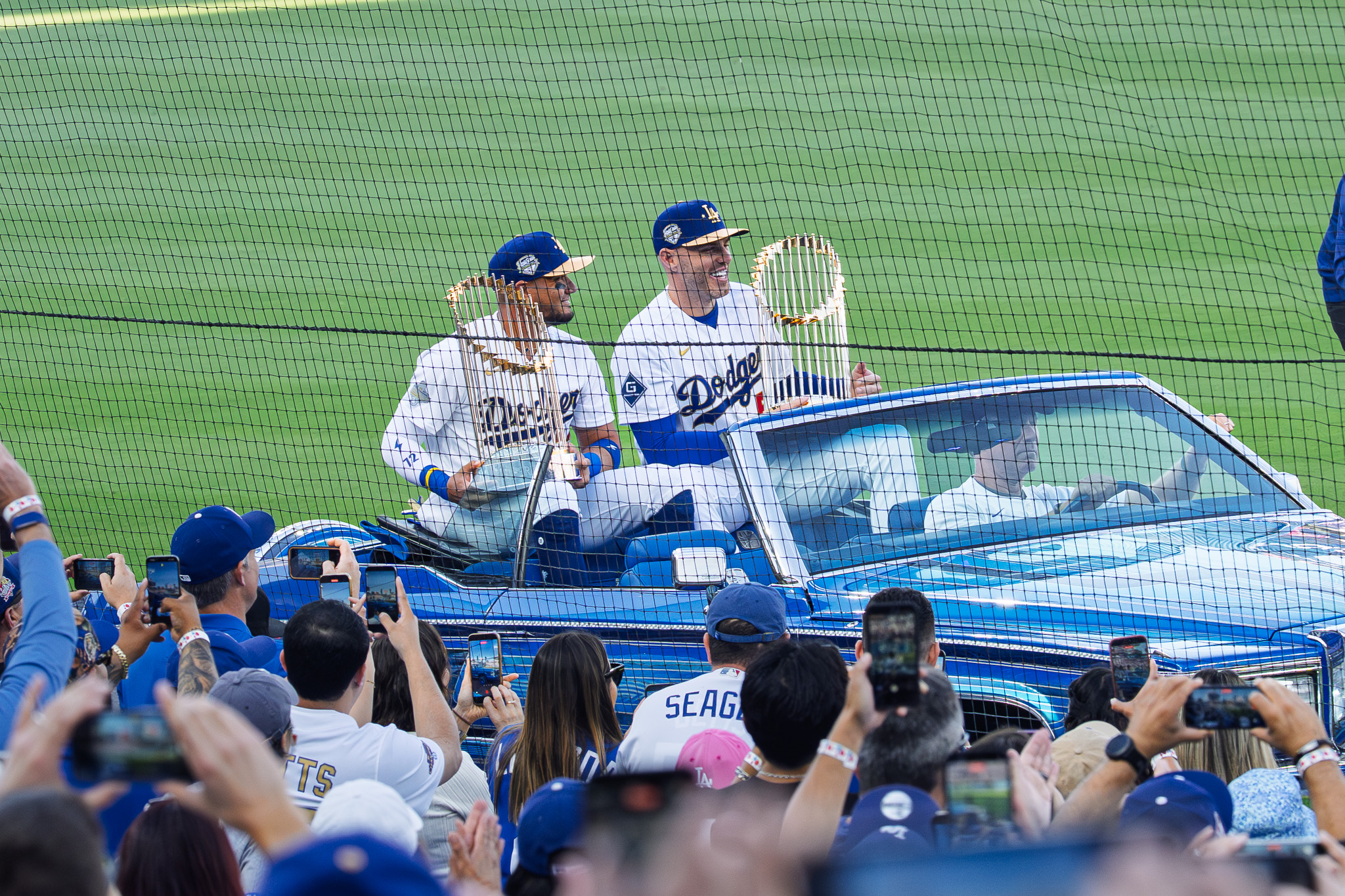 Miguel Rojas and Freddie Freeman holding the World Series trophy on Opening Day at Dodger Stadium, 2026
